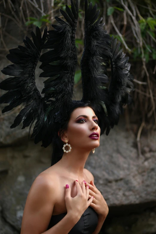 the woman is wearing a huge black feathers headdress