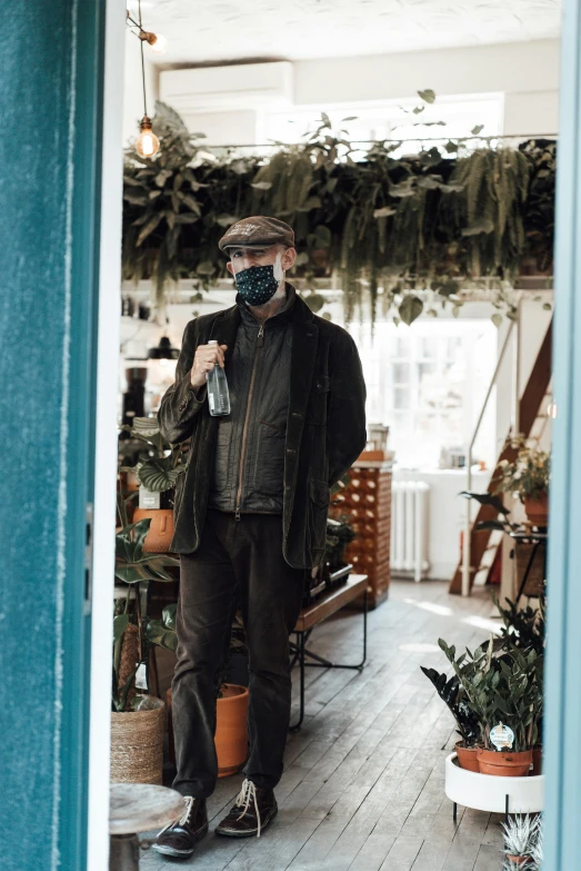 a man in an office, with plants and a face mask on