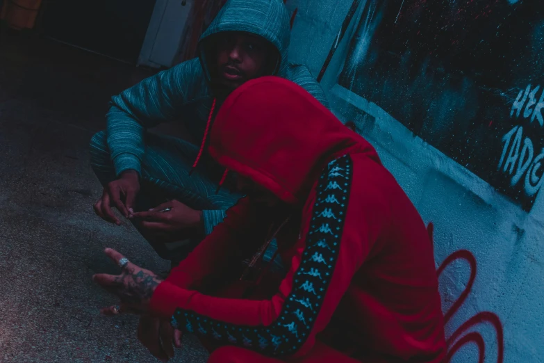 a young man sitting in the street smoking a cigarette