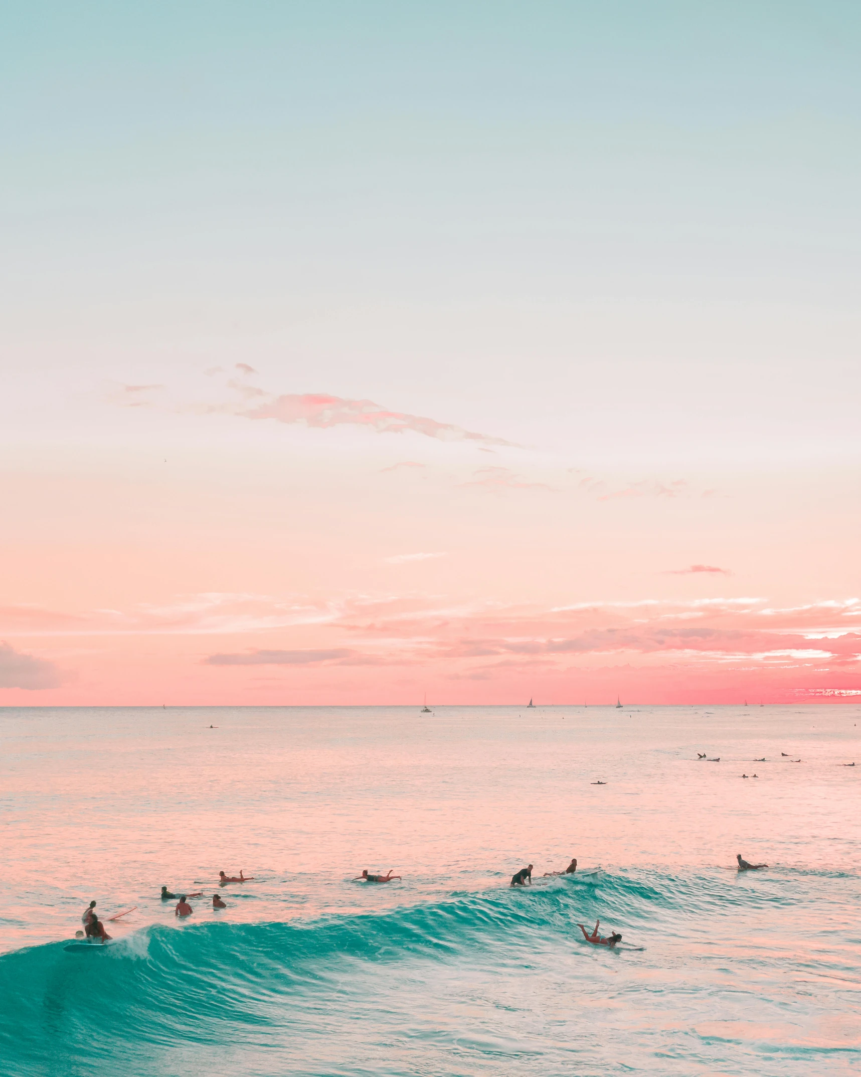 some surfers swimming in the water near a wave