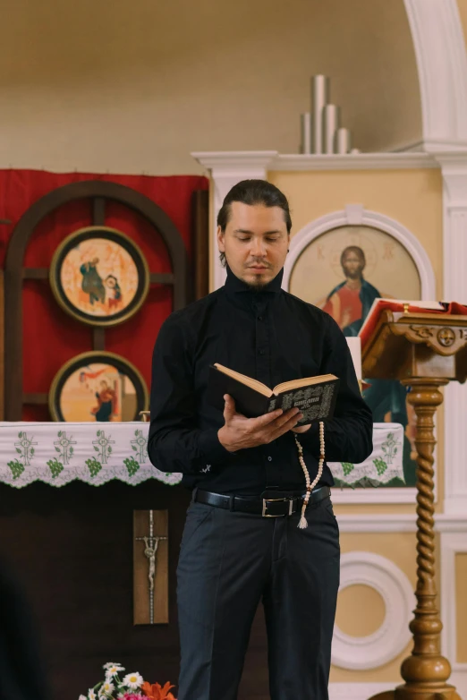 a man standing in front of a alter reading a book