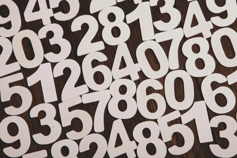 numbers arranged to form large letters on a wooden surface