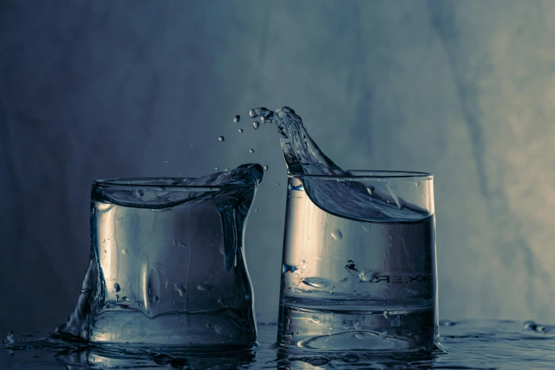 water poured into glass cups with a white background