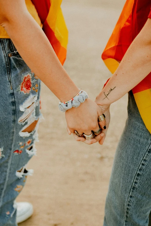 a couple hold hands together as they walk along the beach