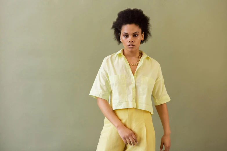 a woman with an afro is standing in front of a green background