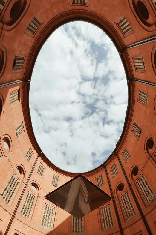 the window in the building is reflecting the sky