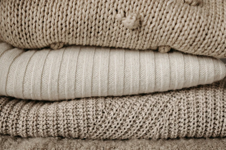 the stack of knitted beige and brown clothing