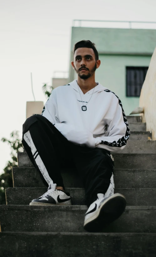 a man with black pants sitting on some steps