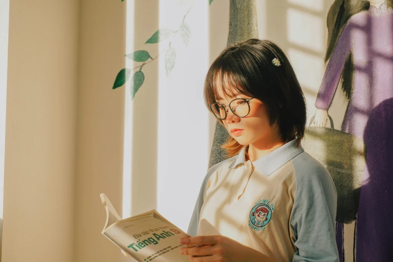 a girl in glasses and a shirt is reading a book