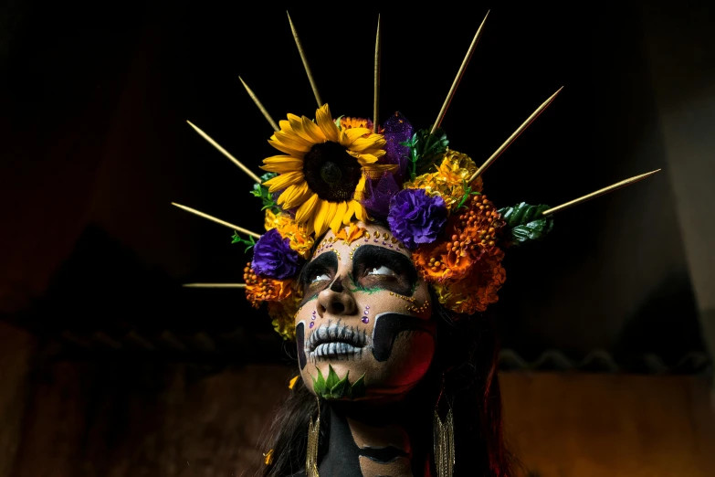 a human mask is made of flowers and sticks