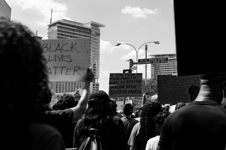 a crowd of people protesting on a street corner