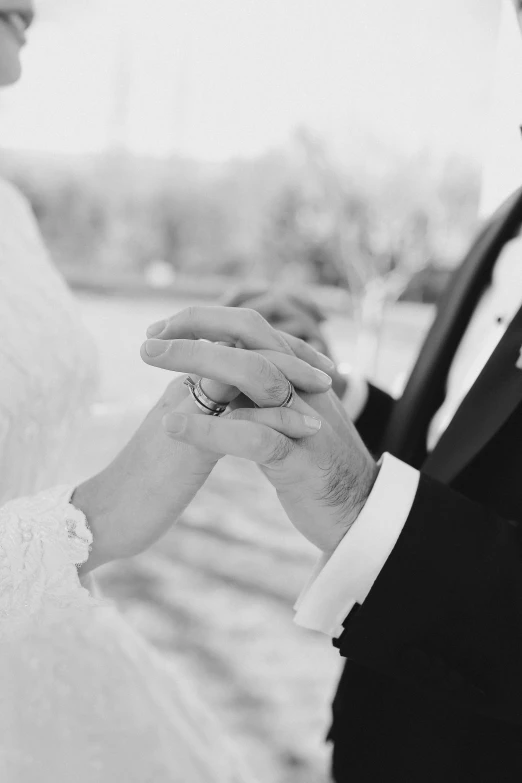 a bride and groom hold each other's hands