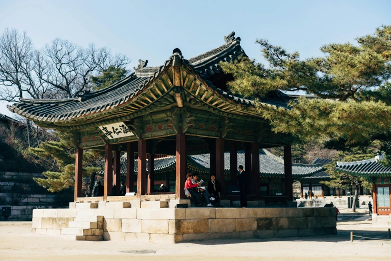 a tall wooden pavilion with several people inside of it