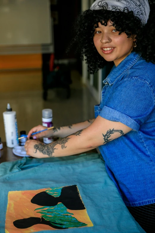 a person sitting down with some tattoos and a t shirt