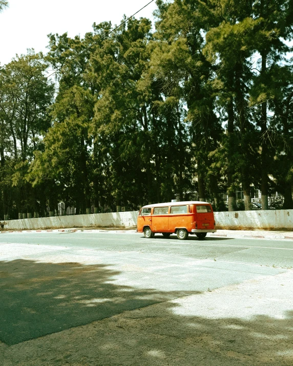 an orange truck is parked beside some trees