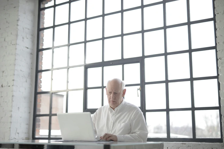 a man is working on a laptop in an office