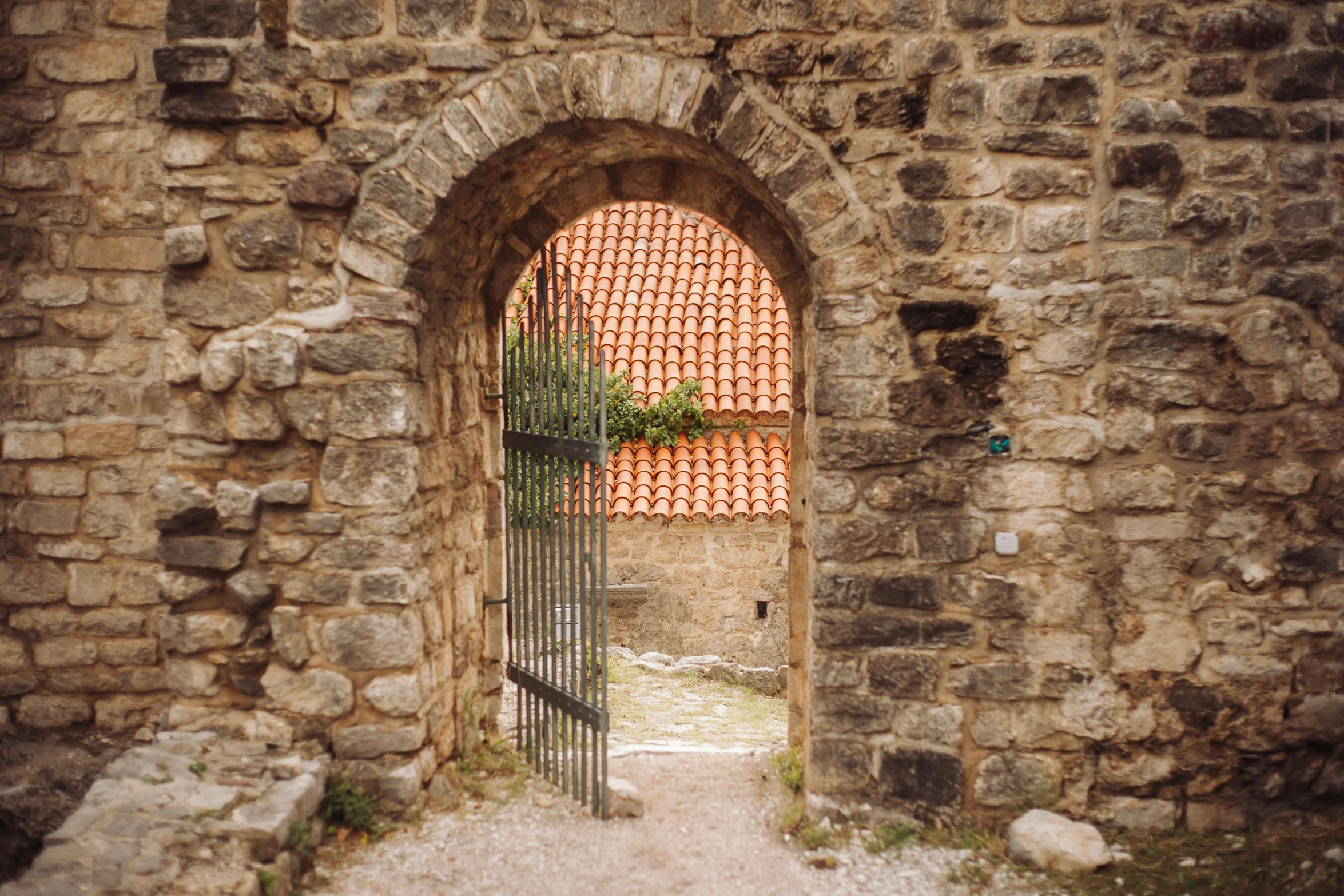 the entrance of an old castle with an iron gate