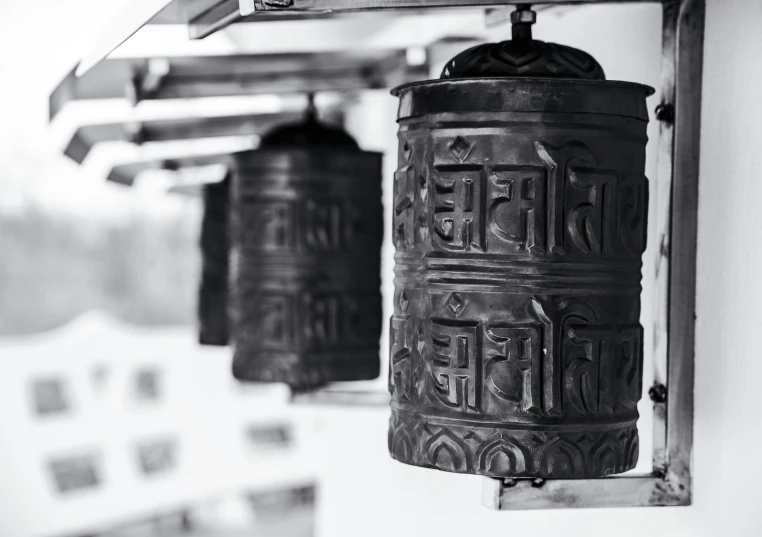 two old bells hanging in front of a wall