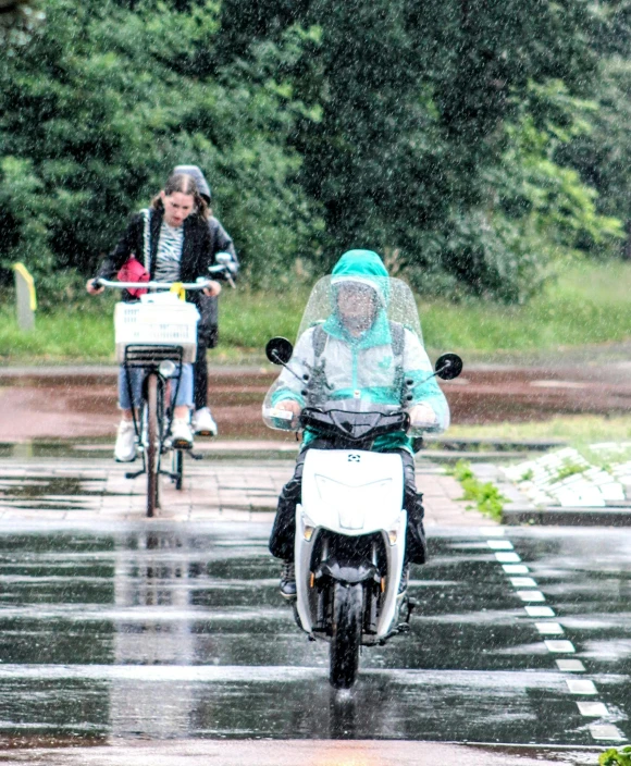 the people are riding bikes in the rain