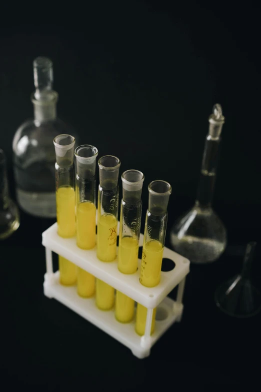 test tubes holding yellow liquids and some empty ones