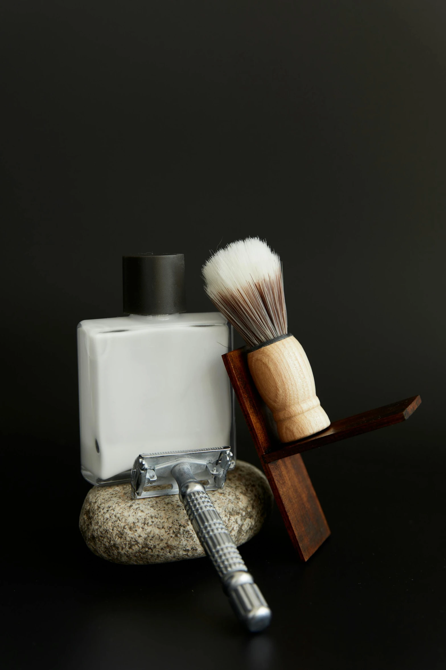 a shaving brush, soap and razor next to it