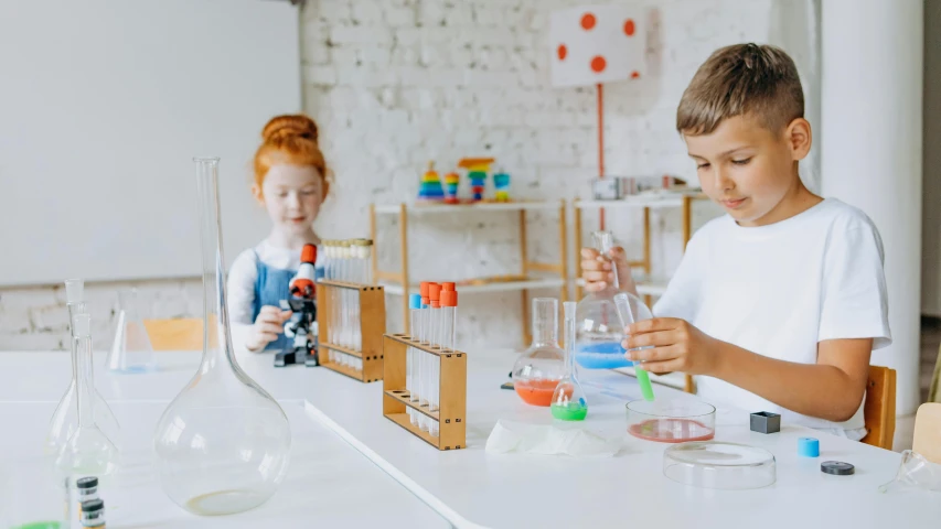 two children doing art project on a table