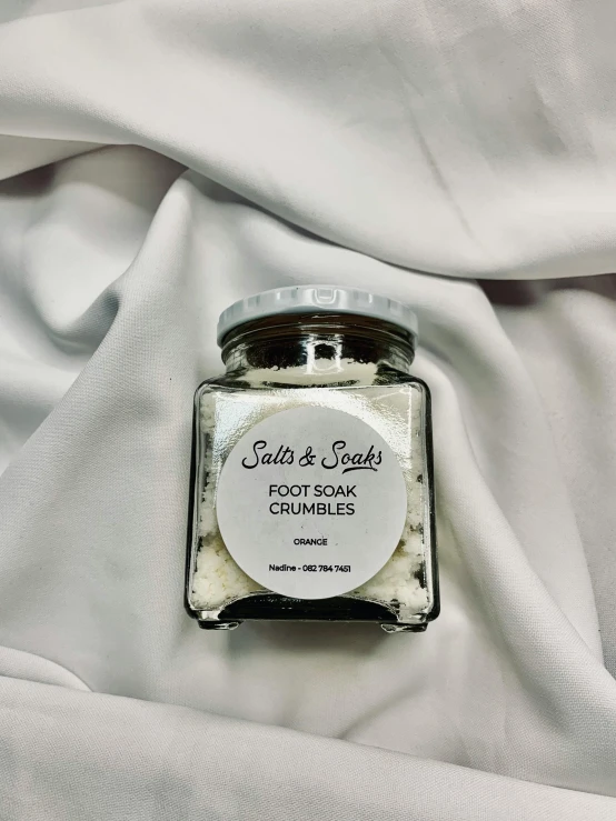 the jar of food sits on top of a white fabric