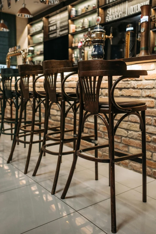 a row of bar chairs and tables with lights on