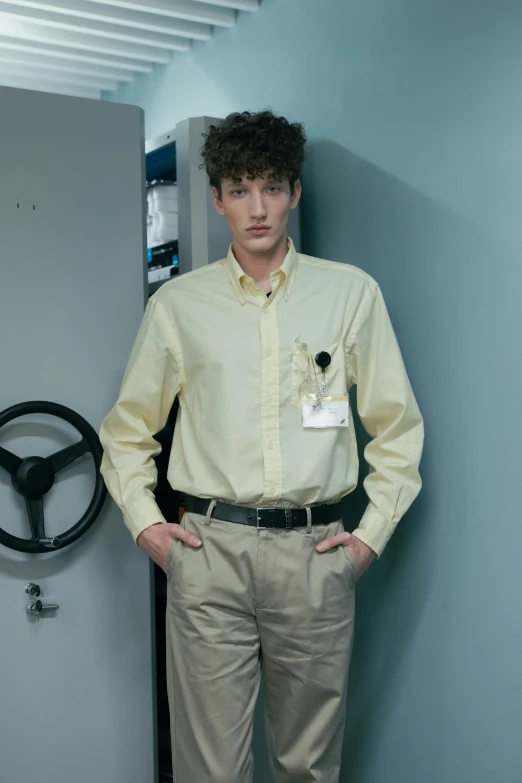 a man in a beige dress shirt standing up