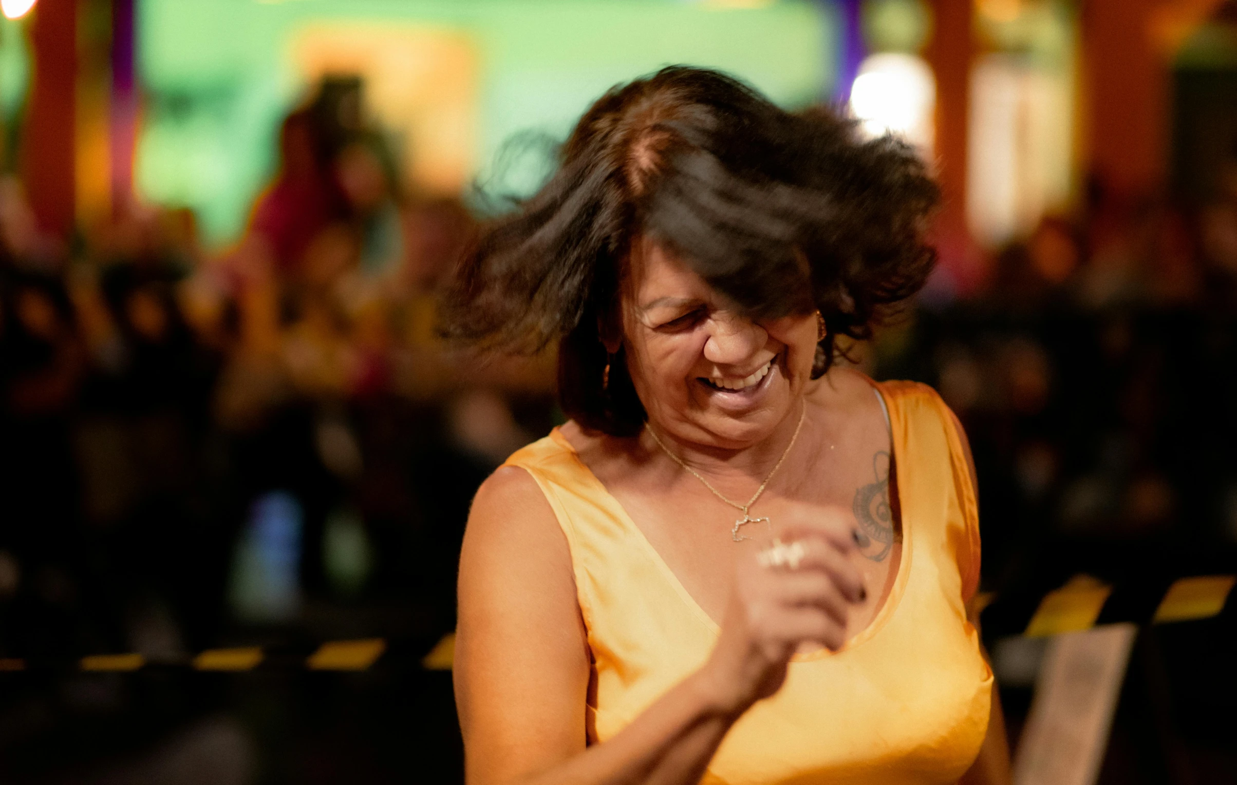 a woman in a yellow dress is looking at her cellphone