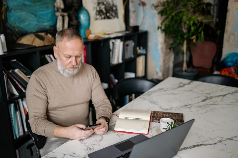 a man that is sitting down with a laptop