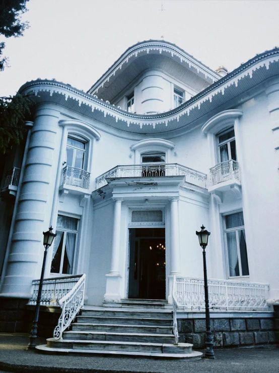 a two story white building with two balconies and a balcony