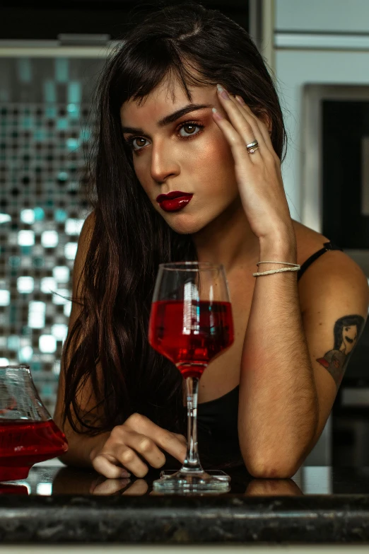 a woman is sitting at the bar with a glass of wine