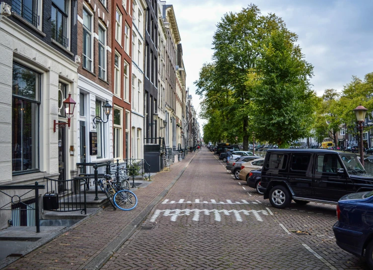 a very quiet street with bicycles and parked cars