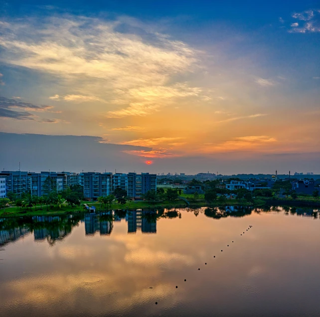 a sunset over some water with buildings around