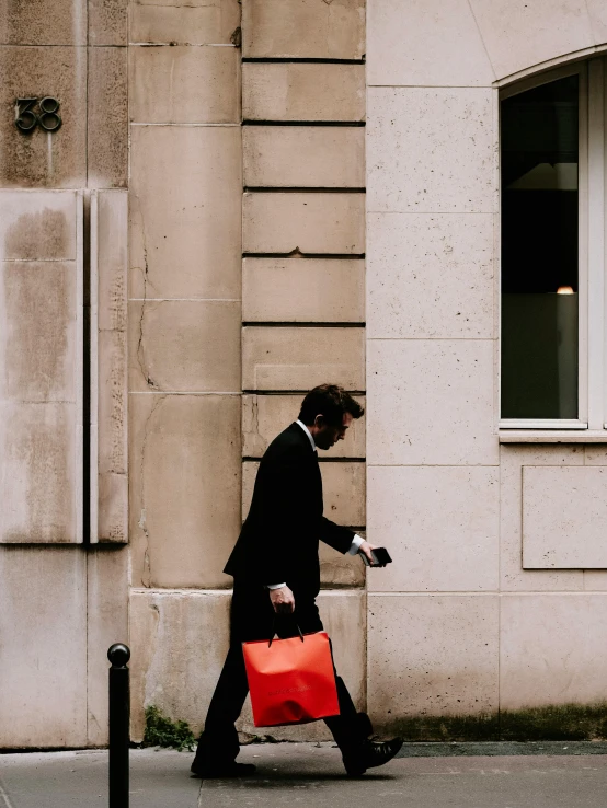 a man is holding onto a red bag