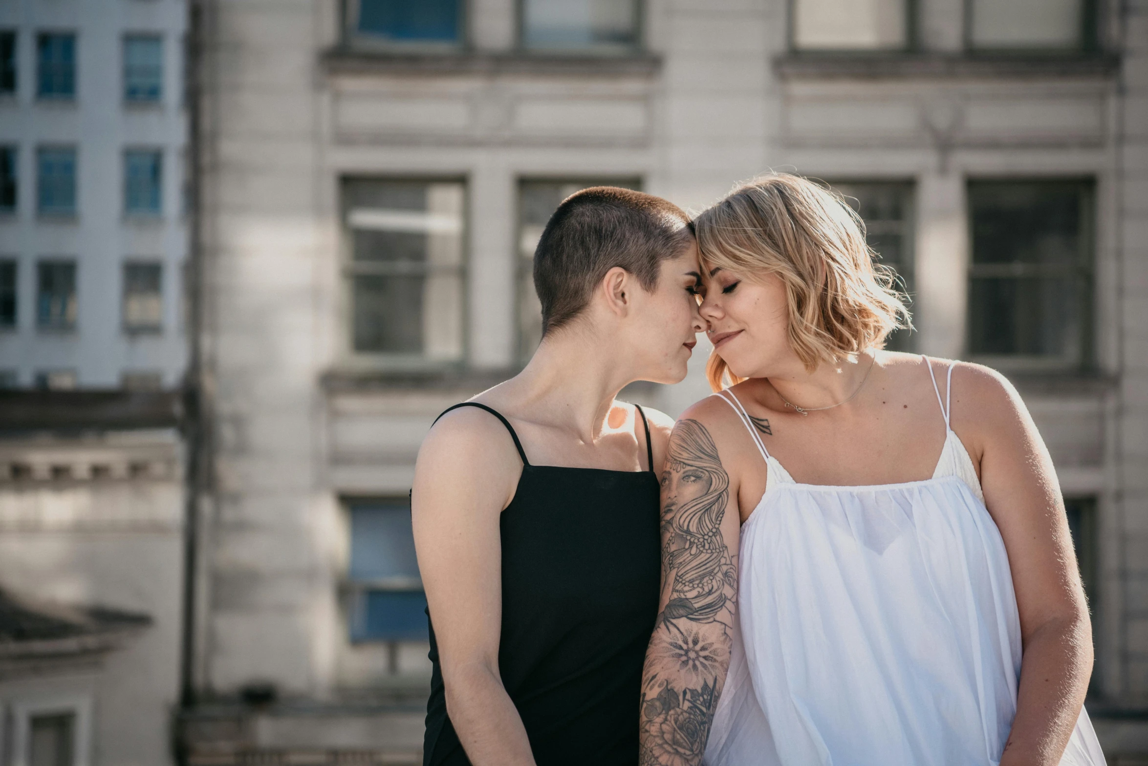 a young couple cuddles with each other on a city street