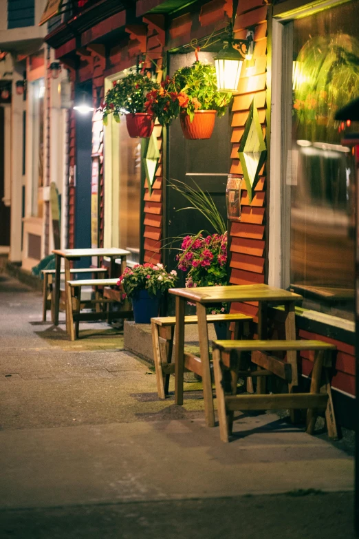 the sidewalk outside a cafe at night in a city