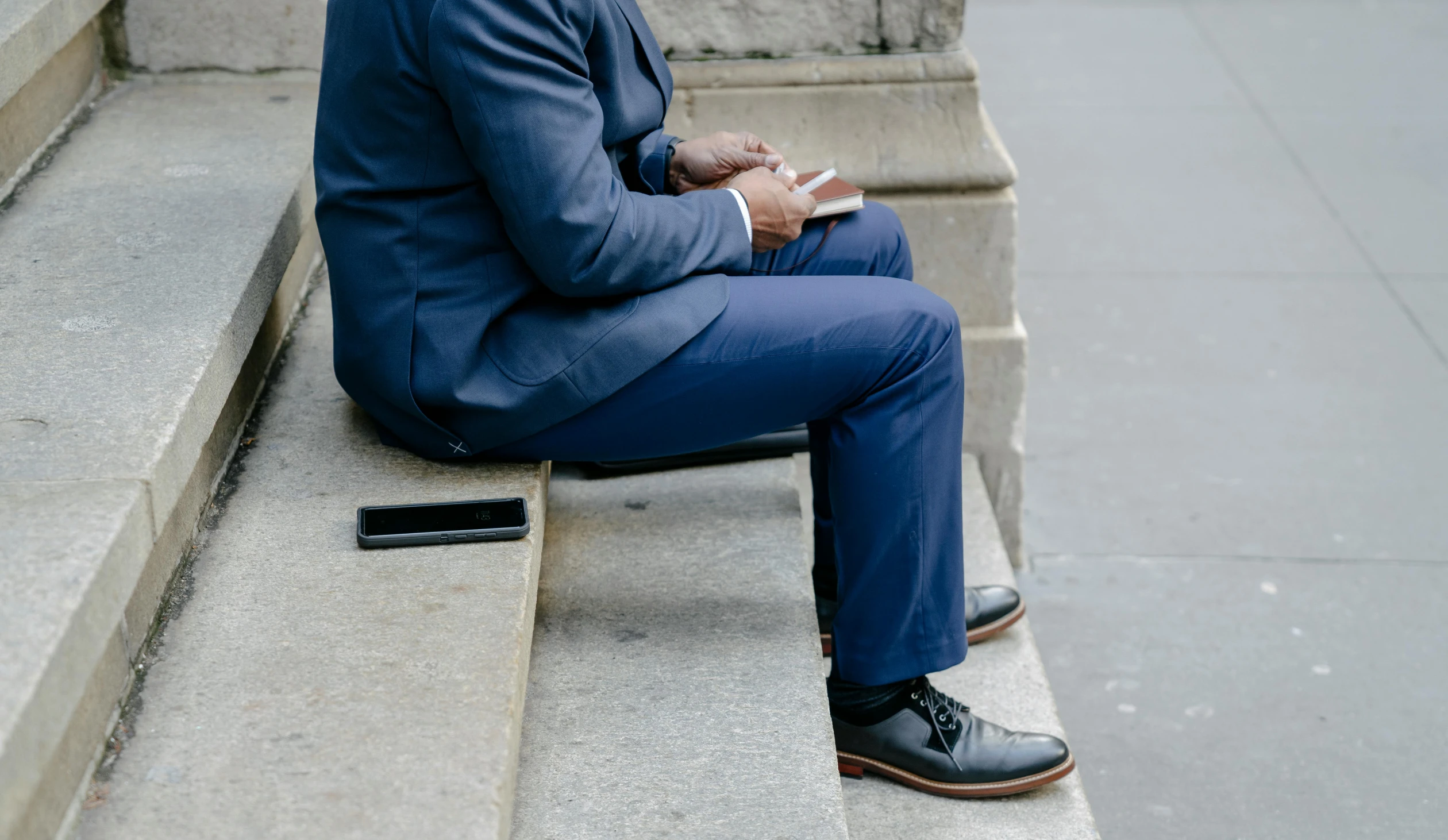 a man sitting on a bench and looking at his phone