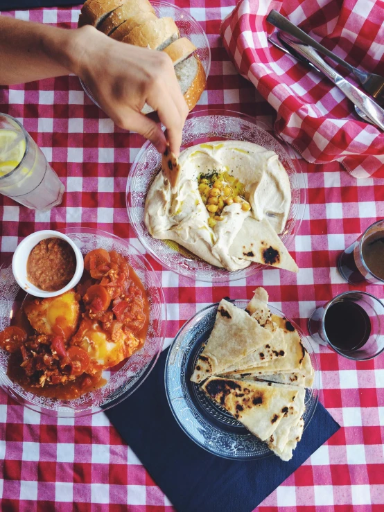 people enjoy eating dinner on a picnic blanket