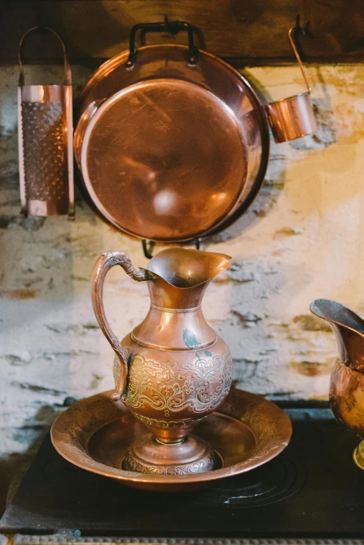 an antique metal pitcher and coffee pot on a stovetop