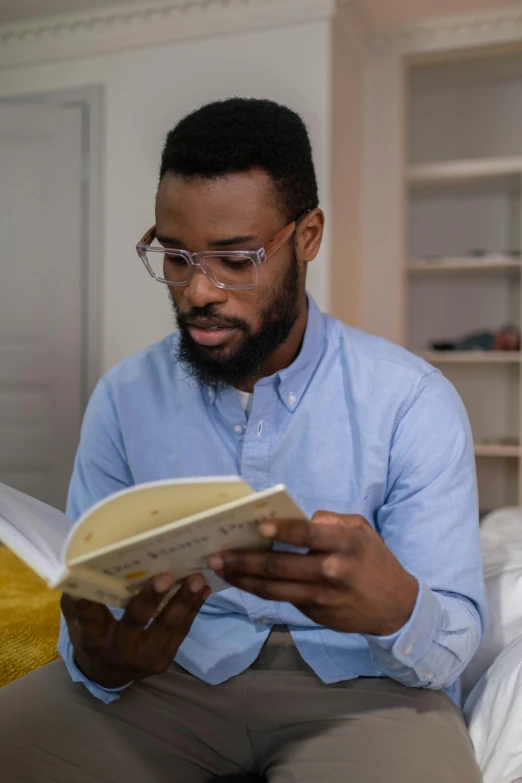 the man is reading a book on his lap