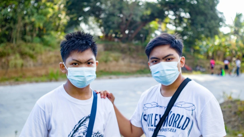 two s wearing face masks on a path