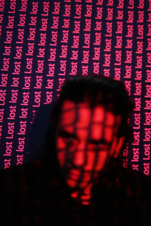a red reflection on a dark background of a person in front of a red and blue wall
