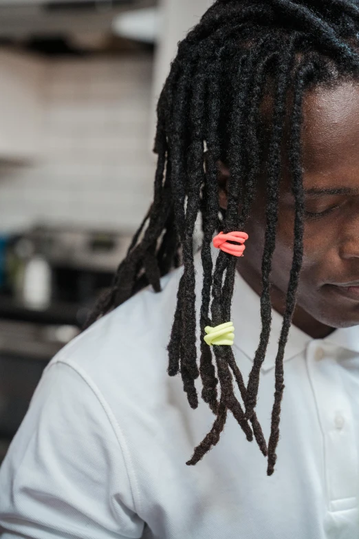 a man in a chef shirt wearing a pair of scissors in his hair