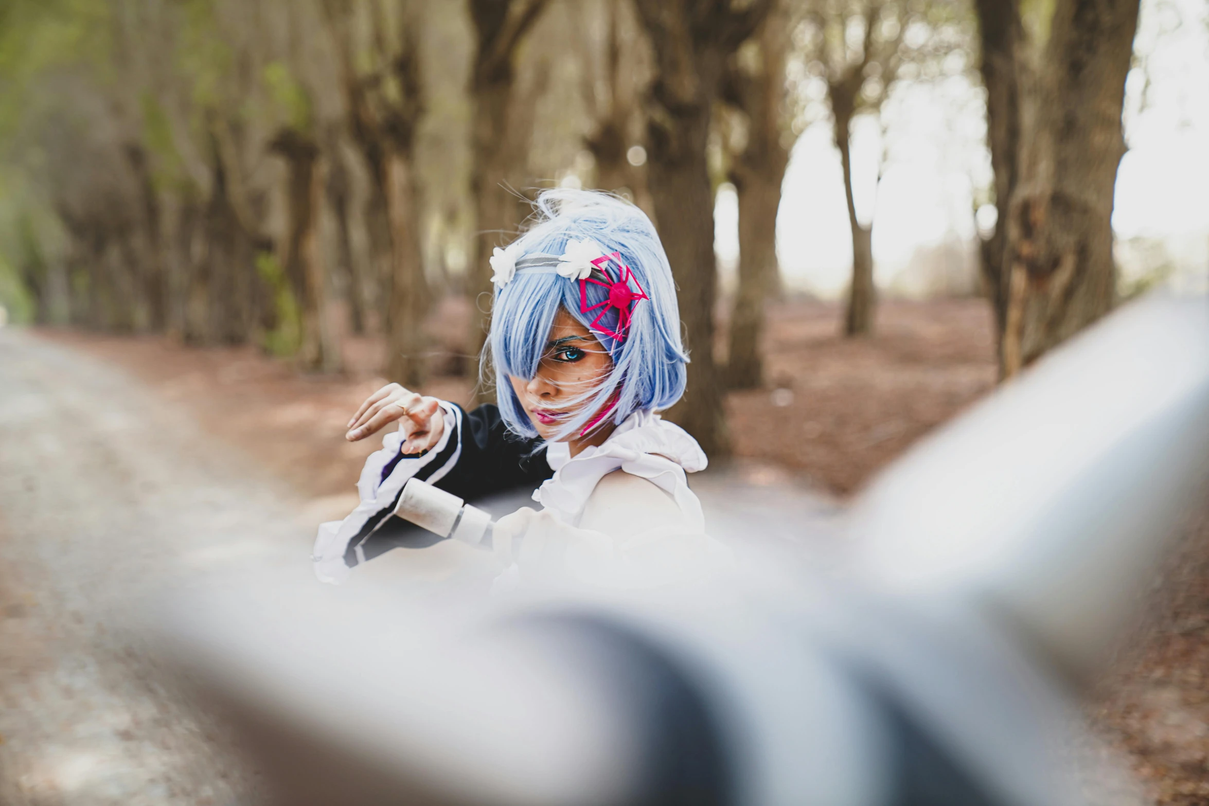 a young lady dressed as an alien pointing to the side with a stick in her hand