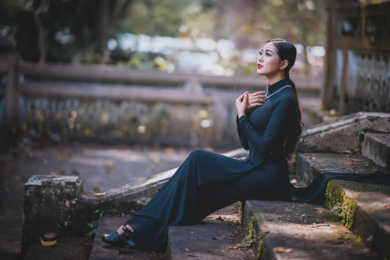 a woman sitting on stairs looking at the sky