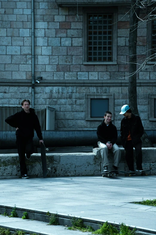 several people are sitting on the steps outside of a building