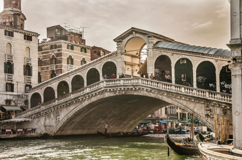 boats in a canal with an arch bridge