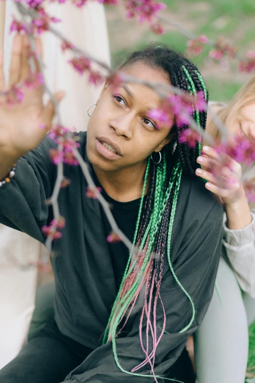 woman with dreadlocks on sits behind plants